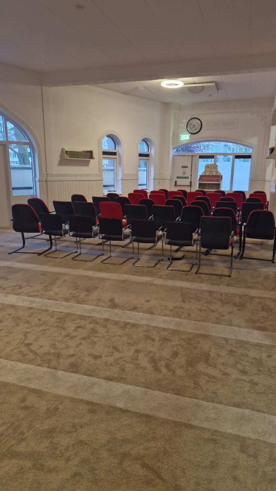 Nevenruimte met stoelen en tapijt
